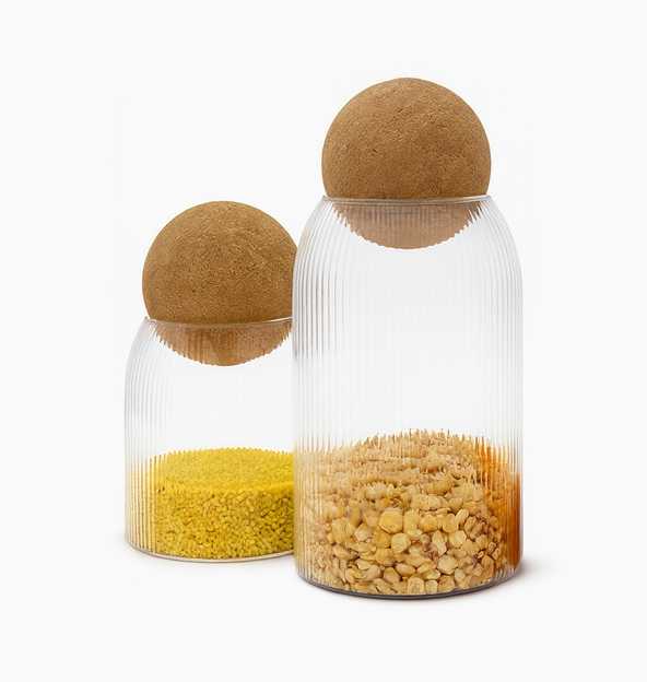Three glass jars with cork lids containing different colored contents on a white background