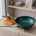 Green wok with orange interior on a blue background