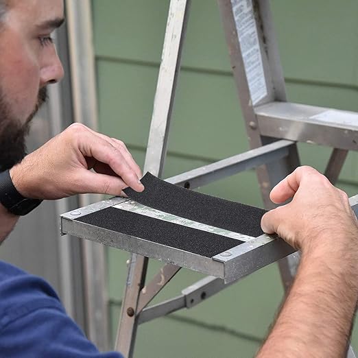 Person installing a step stool on a ladder with a green wall in the background