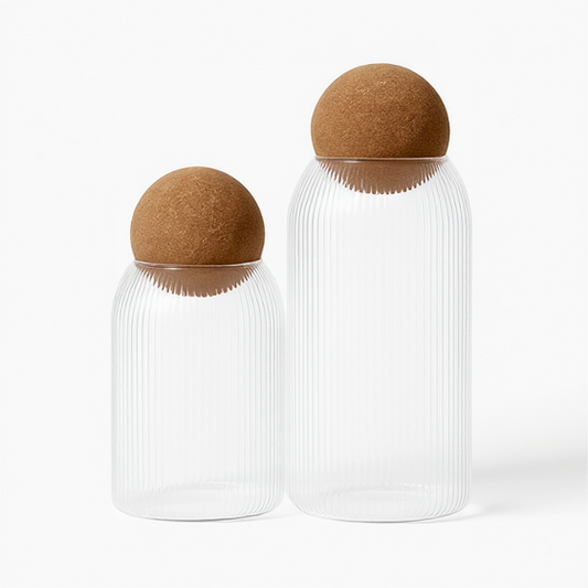 Three glass jars with cork lids on a white background