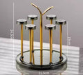 Moving glass stand with rotating gold metal frame and transparent base holding 6 glasses