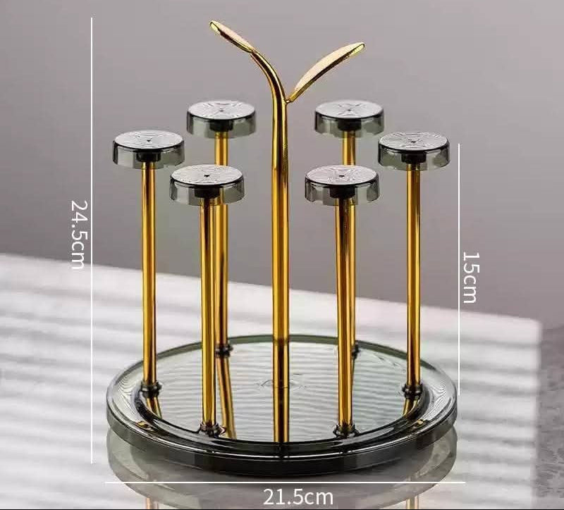 Moving glass stand with rotating gold metal frame and transparent base holding 6 glasses