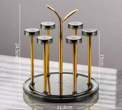 Moving glass stand with rotating gold metal frame and transparent base holding 6 glasses