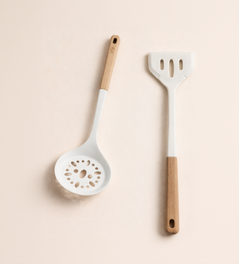 Two kitchen utensils with wooden handles on a beige background